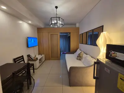 a living room with a bed and a dining room at Family Suite with Big Balcony and Pool View in Manila