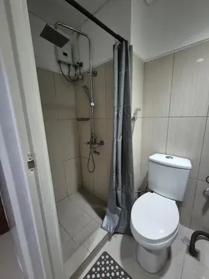 a small bathroom with a toilet and a shower at Family Suite with Big Balcony and Pool View in Manila