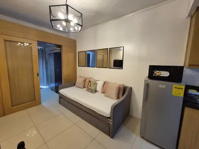 a room with a couch with pillows on it at Family Suite with Big Balcony and Pool View in Manila