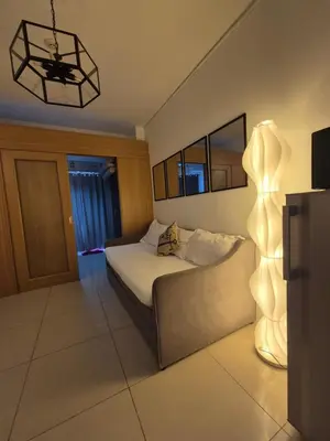 a bedroom with a bed and a lamp in it at Family Suite with Big Balcony and Pool View in Manila