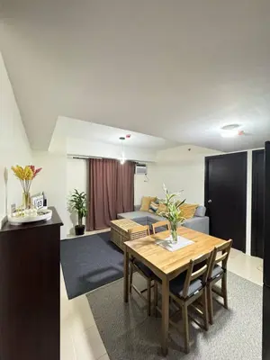 a living room with a table and a couch at City Lights and Cozy nights in Manila