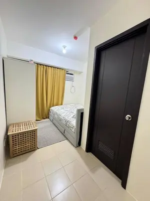 a small bedroom with a bed and a door at City Lights and Cozy nights in Manila