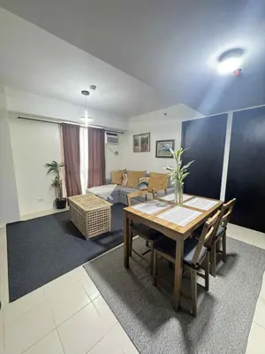 a living room with a table and a couch at City Lights and Cozy nights in Manila