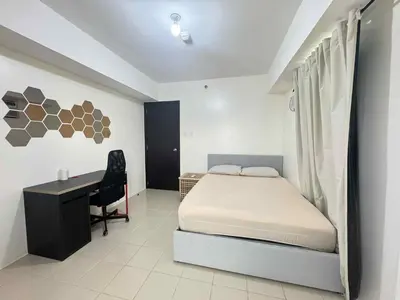 a bedroom with a bed and a desk in it at City Lights and Cozy nights in Manila