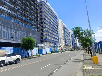 a white car driving down a street with tall buildings at SEA RESIDENCES Golden in Manila