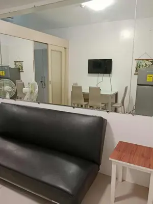 a black leather couch in a room with a table at SEA RESIDENCES Golden in Manila