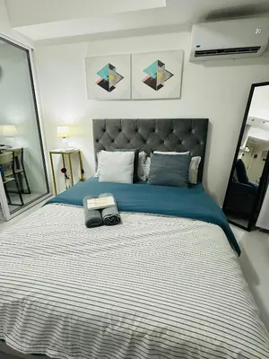 a bedroom with a large bed with a blue blanket at Affordable Boracay-like Staycation in Azure South in Manila