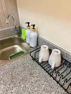 a kitchen counter with two cups and a sink at Walk to Araneta, MRT and Malls, Cubao, Netflix in Manila