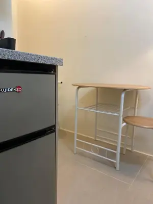 a table and a table and a table and a chair at Walk to Araneta, MRT and Malls, Cubao, Netflix in Manila