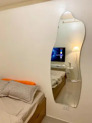 a mirror on the wall of a bedroom with two beds at Walk to Araneta, MRT and Malls, Cubao, Netflix in Manila