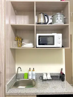a kitchen with a sink and a microwave at Walk to Araneta, MRT and Malls, Cubao, Netflix in Manila