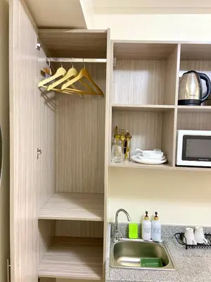 a kitchen with a sink and a microwave at Walk to Araneta, MRT and Malls, Cubao, Netflix in Manila