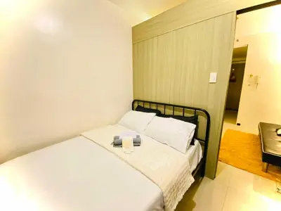 a bedroom with a bed with two candles on it at Shore Residences in Manila