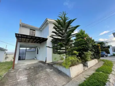a house with a pine tree in front of it at Relaxing 3bedroom home with outdoor dining NUVALI in Calamba