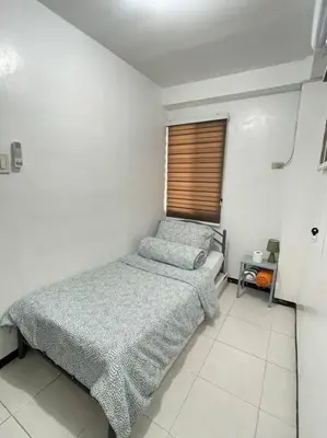 a small bedroom with a bed and a window at Relaxing 3bedroom home with outdoor dining NUVALI in Calamba