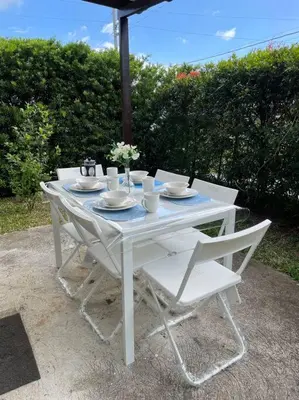 a white table with white chairs and an umbrella at Relaxing 3bedroom home with outdoor dining NUVALI in Calamba