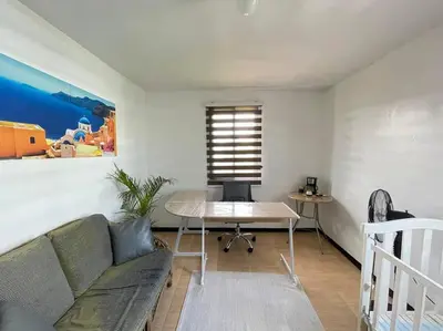 a living room with a couch and a table at Relaxing 3bedroom home with outdoor dining NUVALI in Calamba