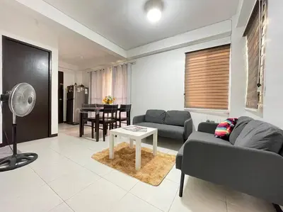 a living room with a couch and a table at Relaxing 3bedroom home with outdoor dining NUVALI in Calamba