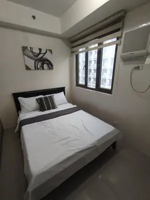 a bedroom with a large bed with a window at Shore D 1422 in Manila