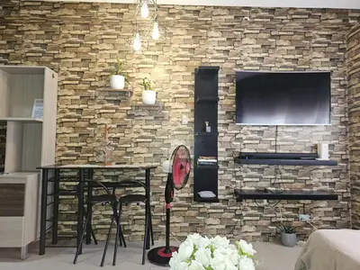 a brick wall with a table and a television at Studio Unit Staycation in Cainta in Cainta