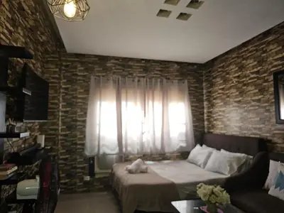 a bedroom with a bed and a couch and a window at Studio Unit Staycation in Cainta in Cainta
