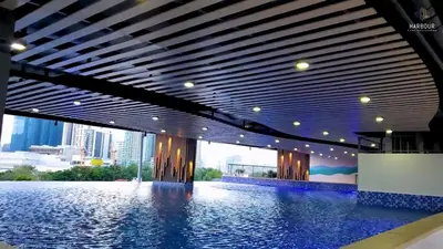 a swimming pool in a building with a view of a city at Cozy Condo in Mandaluyong with Balcony, Pool &Netflix in Manila