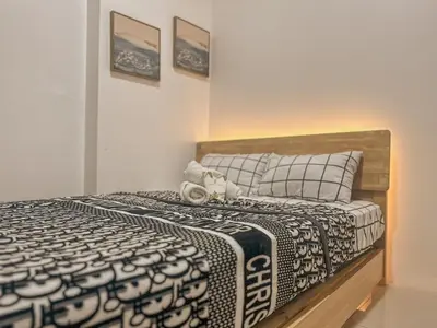a bedroom with a bed with a black and white comforter at Cozy Condo in Mandaluyong with Balcony, Pool &Netflix in Manila
