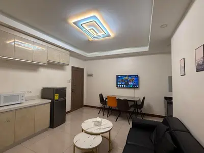 a kitchen and a living room with a couch and a table at 2 AC in 1 Room JCAL Building Near Manila Airports MOA OKADA in Manila