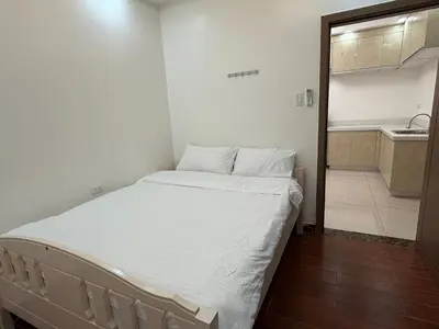 a small bedroom with a bed and a kitchen at 2 AC in 1 Room JCAL Building Near Manila Airports MOA OKADA in Manila