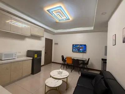 a kitchen and a living room with a couch and a table at 2 AC in 1 Room JCAL Building Near Manila Airports MOA OKADA in Manila