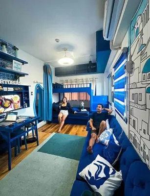 a man and woman sitting on a blue couch in a living room at Staycation in Valley Golf near Antipolo in Cainta