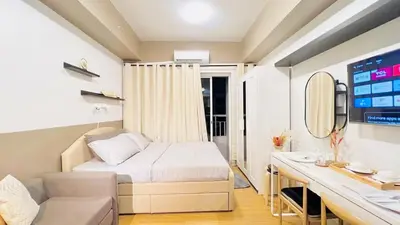 a small bedroom with a bed and a desk at Modern Taguig Staycation Near BGC in Manila