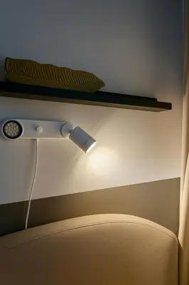 a light on a wall next to a chair at Modern Taguig Staycation Near BGC in Manila