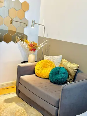 a couch with two pillows on it in a living room at Modern Taguig Staycation Near BGC in Manila