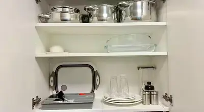 a kitchen shelf with dishes and a mirror in it at Modern Taguig Staycation Near BGC in Manila