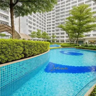 a large blue swimming pool in front of a large building at Modern Taguig Staycation Near BGC in Manila