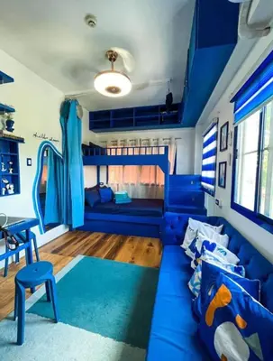 a living room with a blue couch and a slide at Studio Type for Rent along Ortigas Ave Ext in Cainta