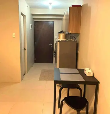a kitchen with a table and two chairs and a door at Modern Studio Condominium 1 in Manila