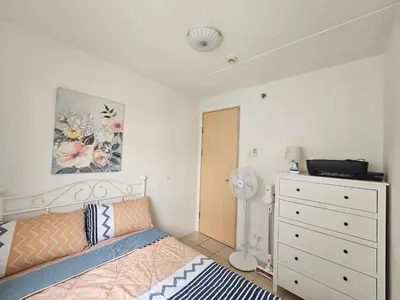 a bedroom with a bed and a dresser in it at Cozy 3-Bedroom Family Condo in Manila