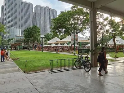 a woman standing next to a bike in a park at Amazing Sunrise View 2 Bed Room, QLED 65-Inch Samsung TV, Disney & Max, Max 5 Adult and 2 kids in Manila