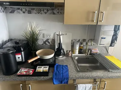 a kitchen counter top with a sink and a stove at Amazing Sunrise View 2 Bed Room, QLED 65-Inch Samsung TV, Disney & Max, Max 5 Adult and 2 kids in Manila