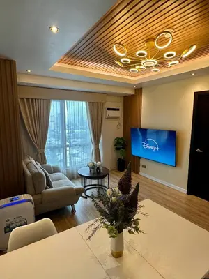 a living room with a couch and a tv at Amazing Sunrise View 2 Bed Room, QLED 65-Inch Samsung TV, Disney & Max, Max 5 Adult and 2 kids in Manila
