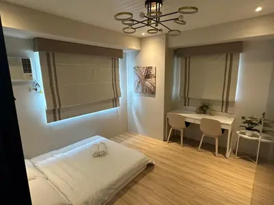 a bedroom with a bed and a desk and a table at Amazing Sunrise View 2 Bed Room, QLED 65-Inch Samsung TV, Disney & Max, Max 5 Adult and 2 kids in Manila