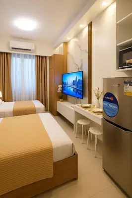 a hotel room with two beds and a flat screen tv at Shore 2 Residences in Manila