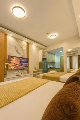 a hotel room with two beds and a kitchen at Shore 2 Residences in Manila