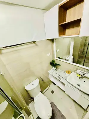 a white bathroom with a toilet and a sink at Shore 2 Residences in Manila
