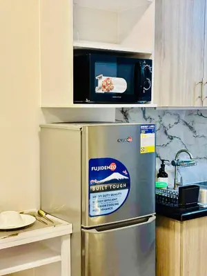 a microwave on top of a refrigerator in a kitchen at Shore 2 Residences in Manila