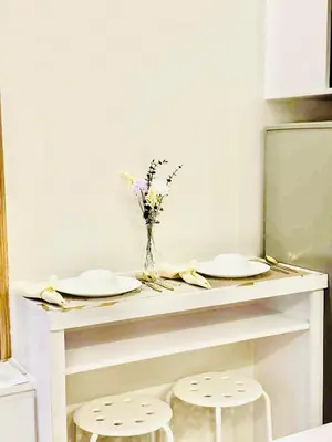 a table with two plates and a vase of flowers at Shore 2 Residences in Manila