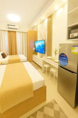 a hotel room with two beds and a refrigerator at Shore 2 Residences in Manila
