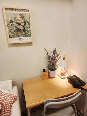 a wooden desk with a phone and a lamp on it at Andi and Frances Place at BGC in Manila